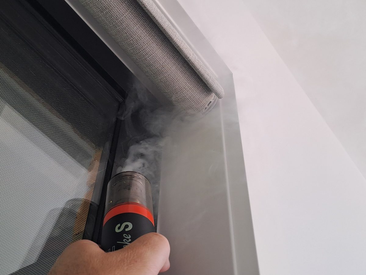 Smoke pencil showing air movement at a window frame during a leak test