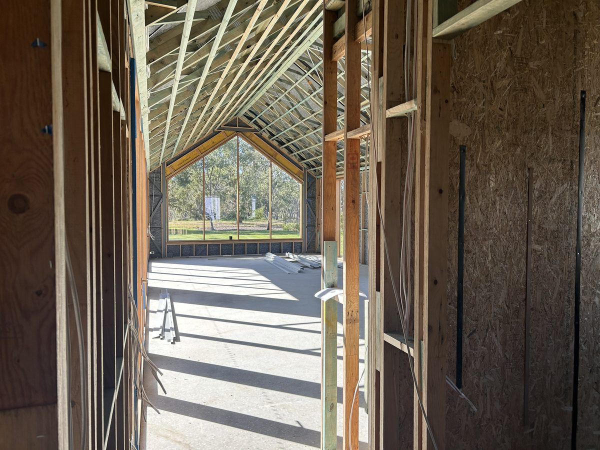 Interior timber framing and vaulted window of a home under construction